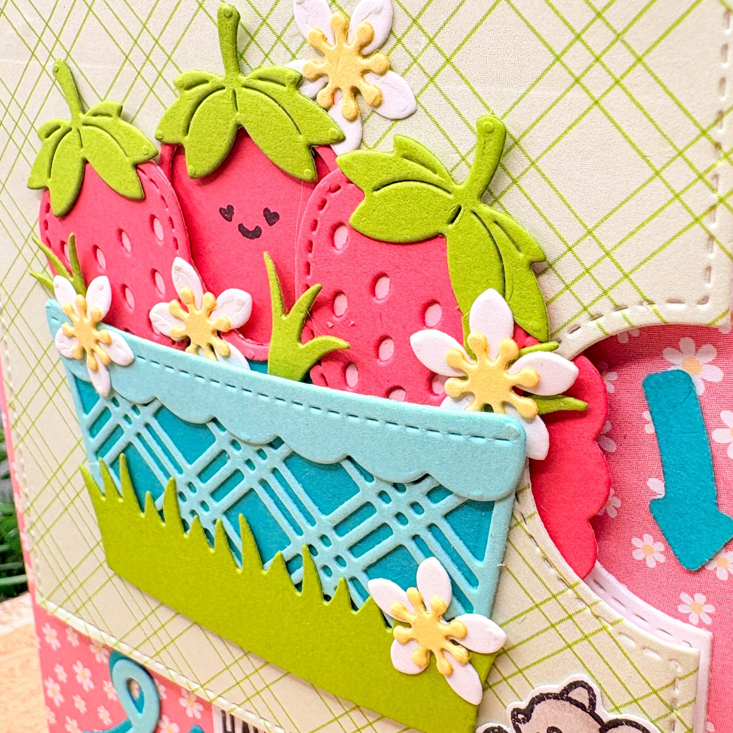 Colorful strawberry-themed card with flowers and a basket on a checkered background