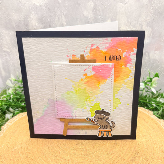 Card with watercolor design and cat illustration on a textured surface