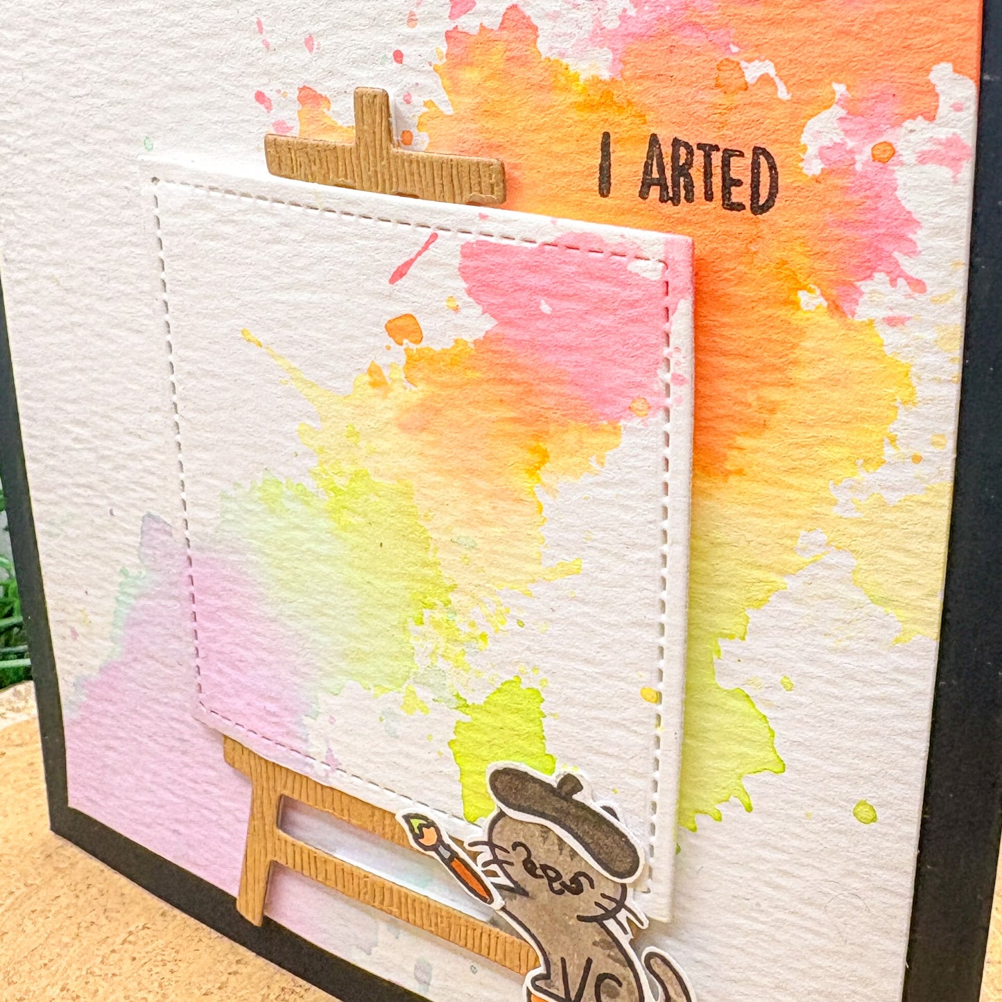 Colorful watercolor splashes with a small figure and 'I Arted' text on a textured background.