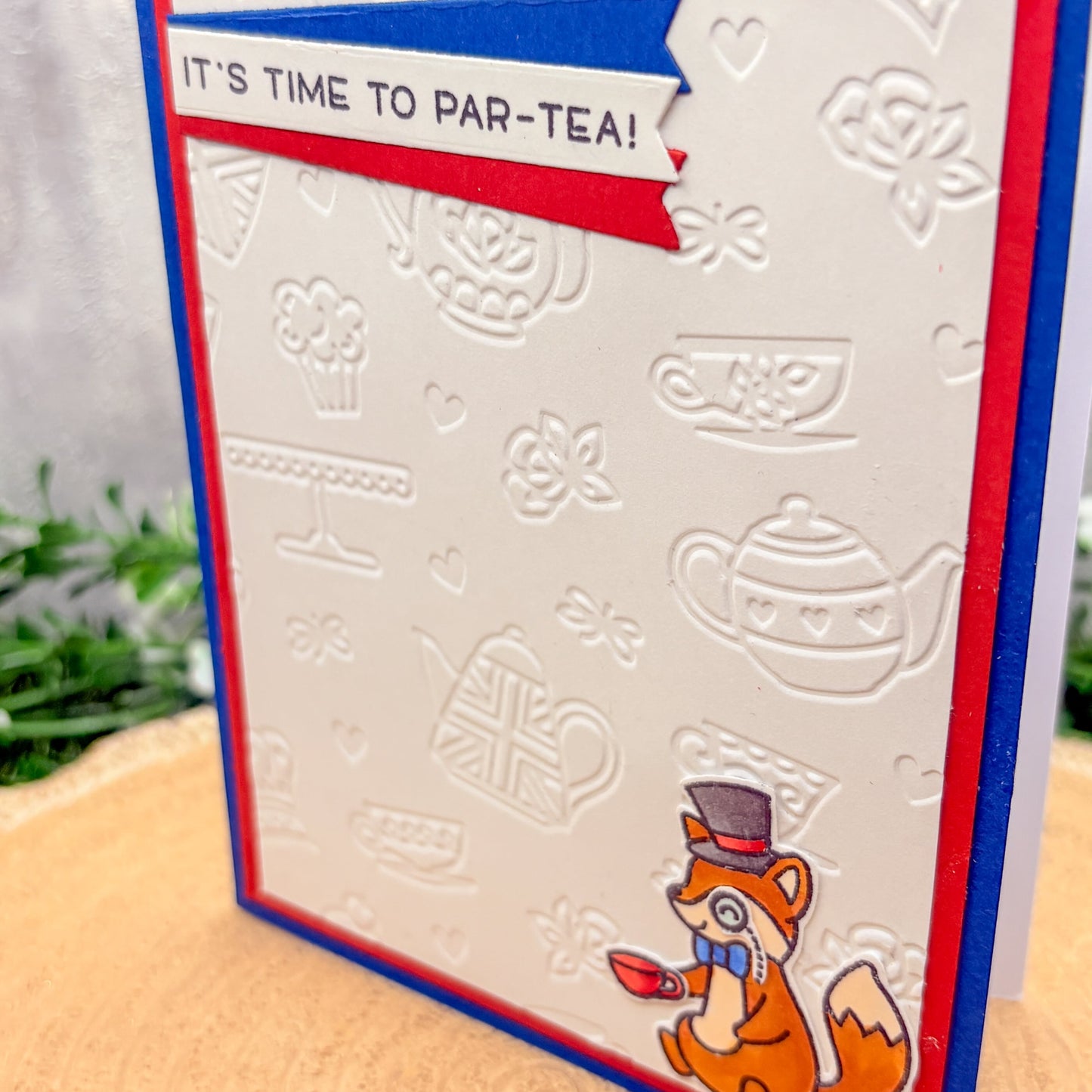 Card with fox illustration and tea-themed design on a wooden surface