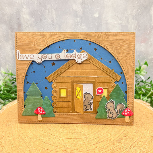 Card with a wooden cabin, trees, and a squirrel design, featuring the text 'love you a lodge'.