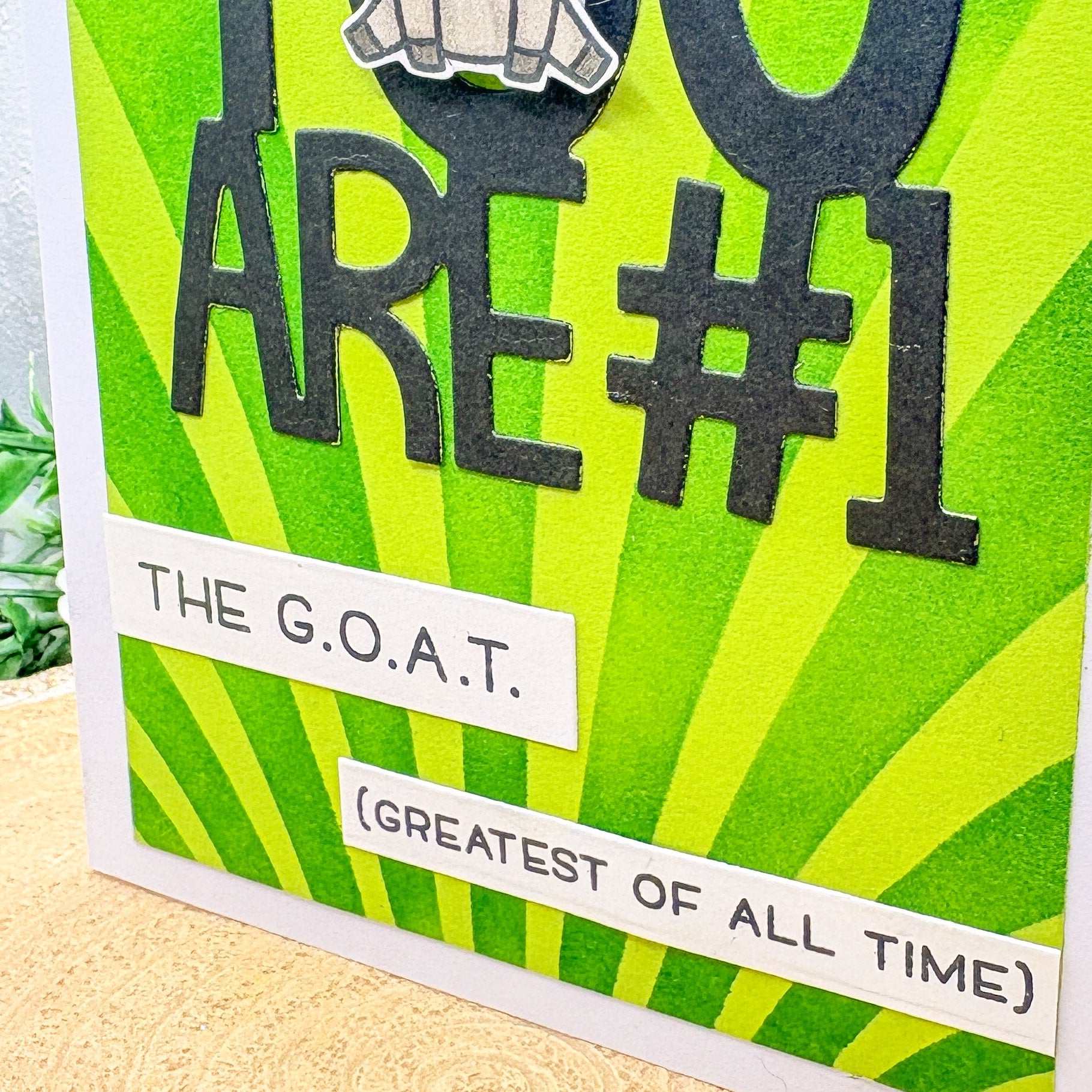 Card with green and black design, text 'YOU ARE #1 THE G.O.A.T. (GREATEST OF ALL TIME)' on a striped background.